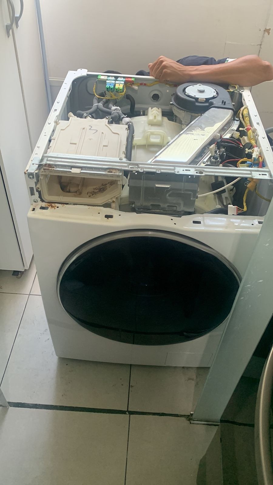 Técnico da FKR Prime realizando manutenção em uma lava e seca na residência do cliente